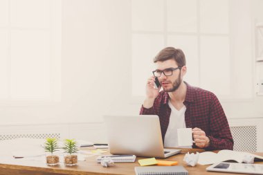 Modern beyaz ofis içinde laptop ile genç ciddi iş adamı