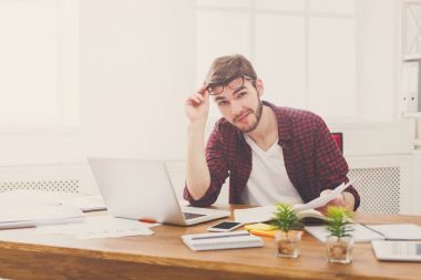 Genç işadamı modern beyaz ofis içinde laptop ile rahat