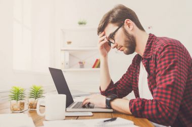 Genç işadamı modern beyaz ofis içinde laptop ile çalışma