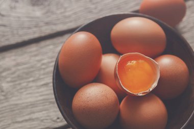 Ahşap arka plan üzerinde kase taze kahverengi yumurta