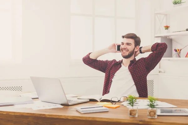 Young santai pengusaha memiliki percakapan mobile di kantor putih modern — Stok Foto