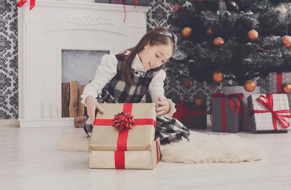 Menina bonita desembrulhando presentes de Natal — Fotografia de Stock