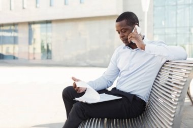 Afrikalı-Amerikalı işadamı açık havada belgelerle çalışma