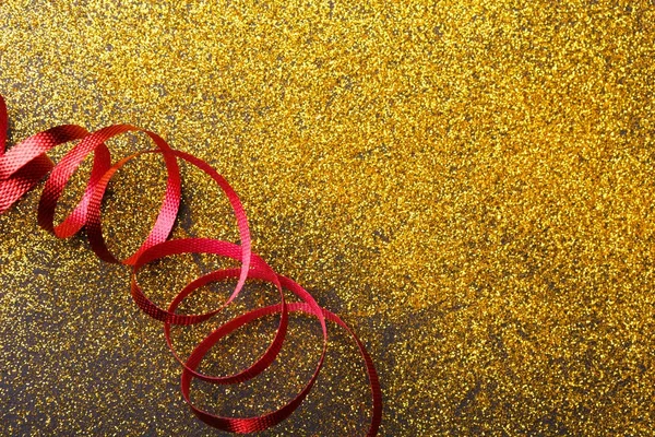 Serpentine rouge bouclée sur fond de paillettes — Photo