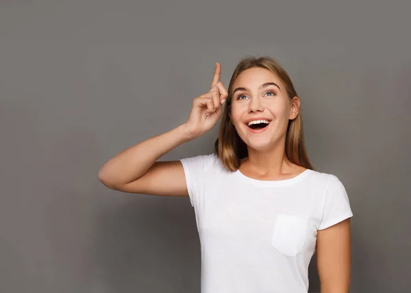 Felice giovane donna che punta in su — Foto Stock