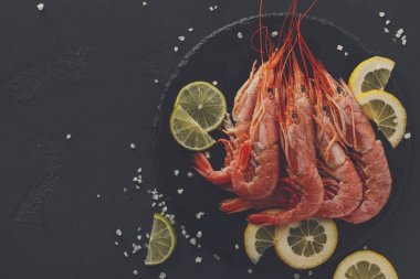 Siyah arka plan üzerine limon ve tuz ile karides