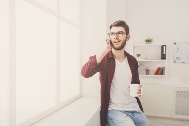 Kendine güvenen genç işadamı ofis pencere yakınındaki