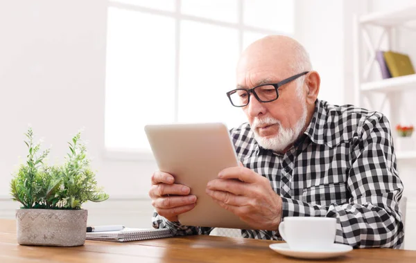 Senior liest Nachrichten auf digitalem Tablet — Stockfoto