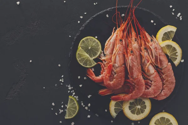 Siyah arka plan üzerine limon ve tuz ile karides