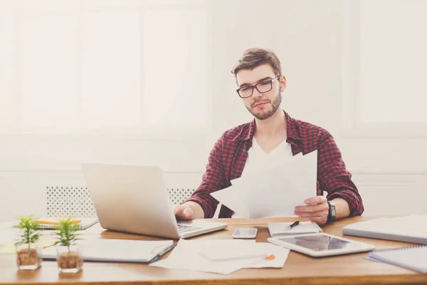 Ung koncentrerad affärsman med laptop i modern vit office — Stockfoto