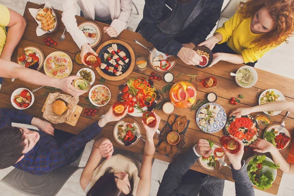 People eat healthy meals and drink at served table dinner party