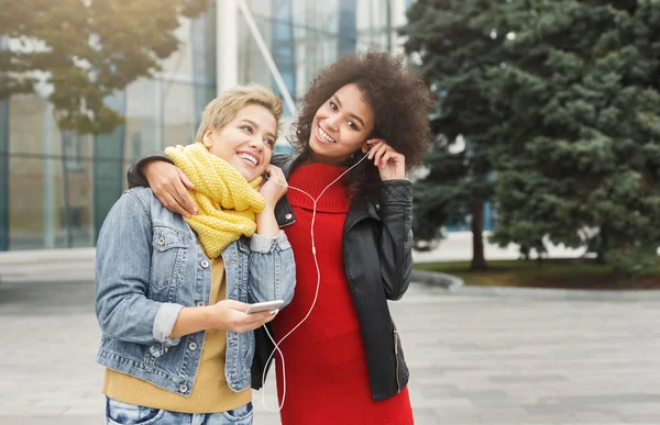 Felices amigas escuchan música al aire libre —  Fotos de Stock