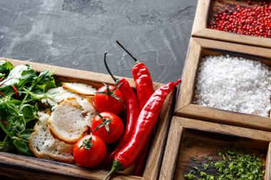 Malzemeler ve koyu arka plan üzerinde ahşap kutu otlar pişirme