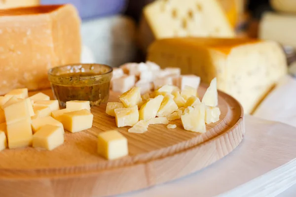 Bandeja de queso, parmesano en plato de madera natural con salsa — Foto de Stock