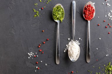 Kaşık koyu arka plan, üstten görünüm, tarih içinde çeşitli baharatlar alanı Kopyala