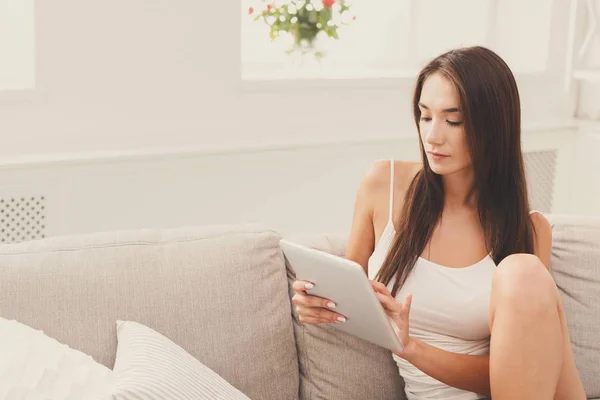 Giovane ragazza premurosa con un tablet a casa — Foto Stock