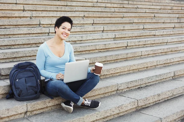 Student zâmbitor stând pe scări folosind laptopul — Fotografie, imagine de stoc