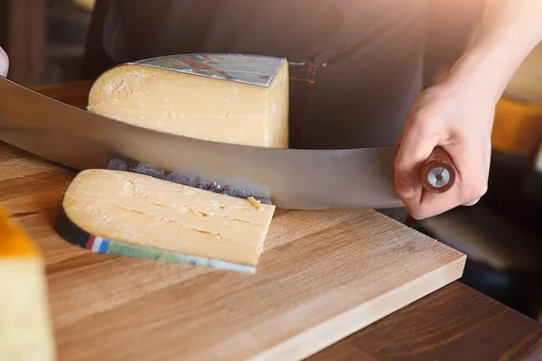 Резка твердых сыров в продуктовом магазине — стоковое фото
