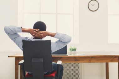 Modern beyaz ofiste rahat siyah işadamı