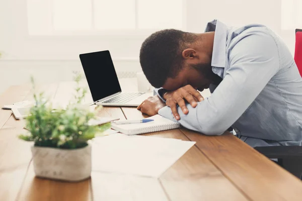Sleeping overworking black businessman with laptop