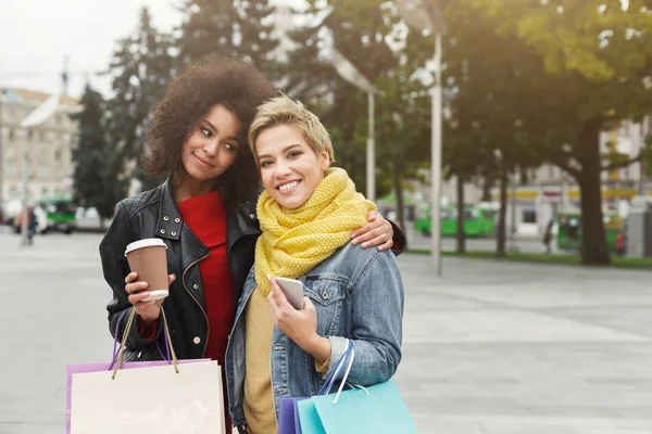Amigos felizes do sexo feminino com sacos de compras ao ar livre — Fotografia de Stock