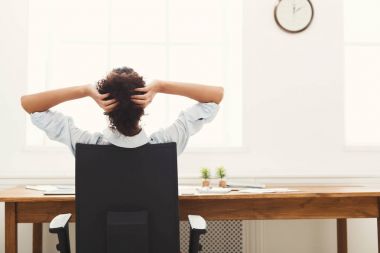 Ellerini başının arkasına ile ofiste dinlenme iş kadını