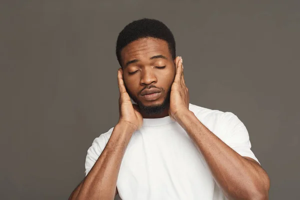 Hombre negro cubriendo orejas con las manos — Foto de Stock