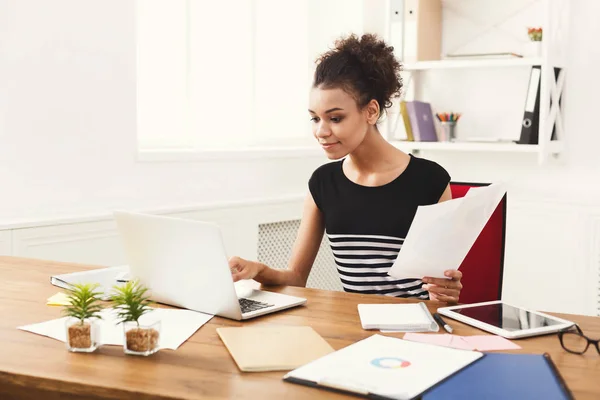 Vrouw lezing bedrijfsdocument op office-bureaublad — Stockfoto