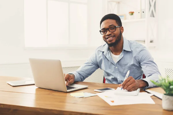 Jonge zwarte zakenman werken met laptop — Stockfoto