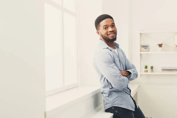 Unga happy svart man poserar vid fönster — Stockfoto