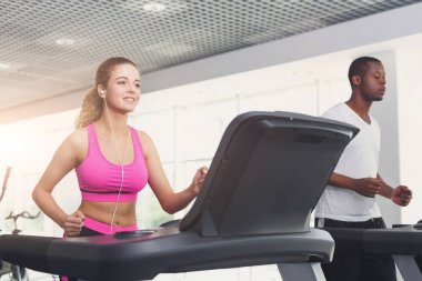 Erkek ve kadın, çift koşu bandı üzerinde spor salonunda