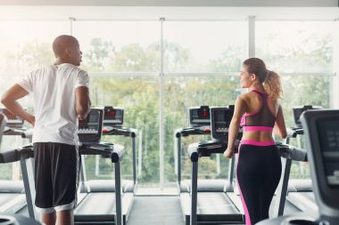 Erkek ve kadın, çift koşu bandı üzerinde spor salonunda