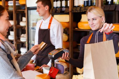 Bakkal dükkanı beyaz peynir sırasını için ödeme müşteri.