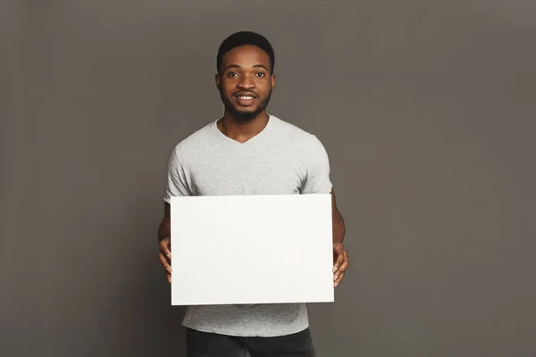 Εικόνα του νεαρού Αφροαμερικανός κρατώντας το λευκό κενό πίνακα — Φωτογραφία Αρχείου