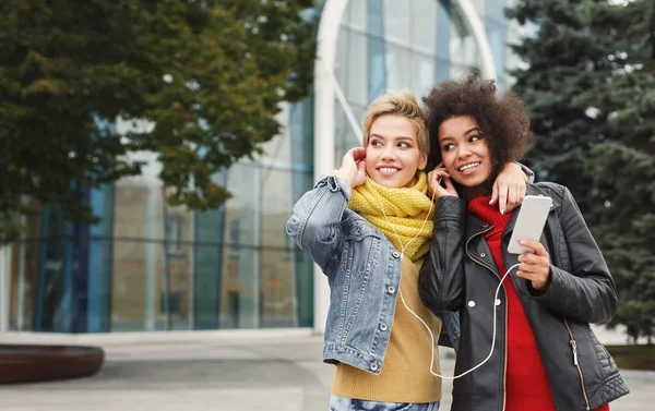 Felices amigas escuchan música al aire libre —  Fotos de Stock