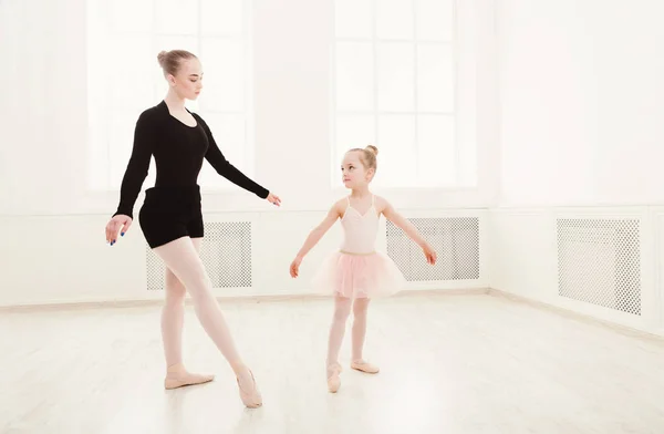 Little girl looking at professional ballet dancer