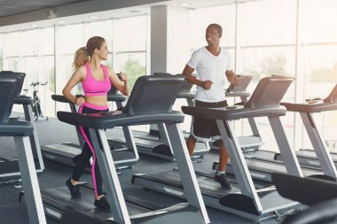 Erkek ve kadın, çift koşu bandı üzerinde spor salonunda