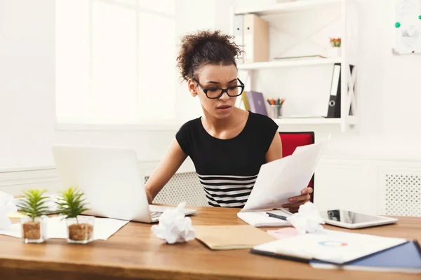 Ernstige vrouw lezing bedrijfsdocument op office-bureaublad — Stockfoto