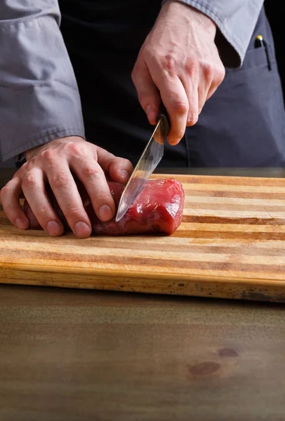 Chef memotong filet mignon di papan kayu di dapur restoran — Stok Foto