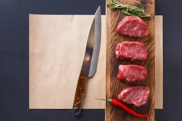 Filete de ternera crudo mignon filetes en tablero de madera y papel artesanal — Foto de Stock