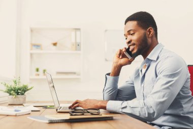 Cep telefonu üzerinde konuşurken genç siyah işadamı
