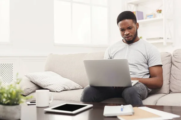 Jovem em casa mensagens on-line no laptop — Fotografia de Stock