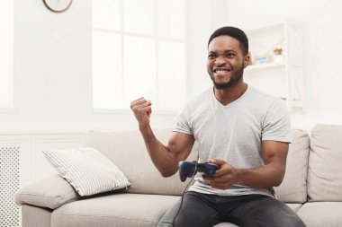 Video oyunları ve WINS mutlu genç Afro-Amerikan adam evde oynarken