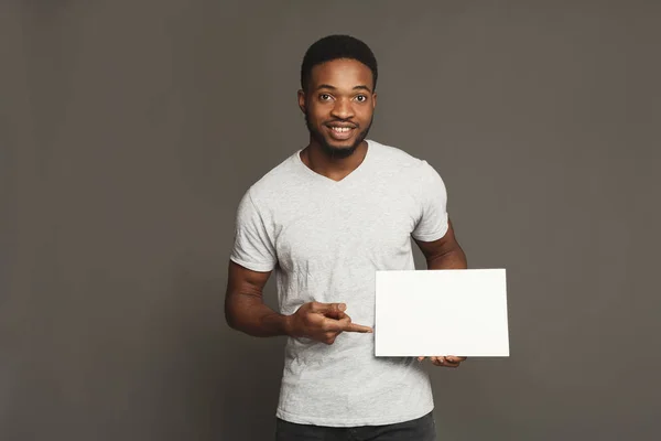 Imagen del joven afroamericano sosteniendo pizarra blanca en blanco — Foto de Stock