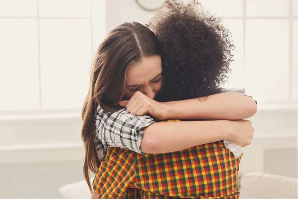 Женщина обнимает своего депрессивного друга дома — стоковое фото