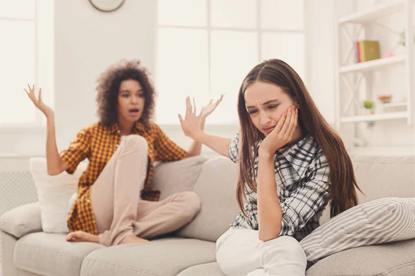 Dos amigas sentadas en un sofá discutiendo —  Fotos de Stock