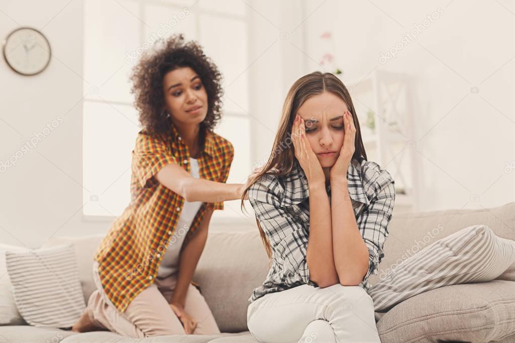 Woman consoling her depressed friend at home