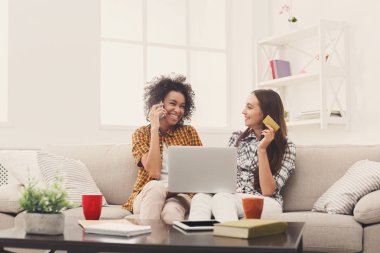 Kredi kartı ve dizüstü bilgisayar ile iki kadın online