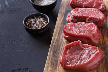 Ham sığır fileto biftek blac, ahşap tahta üzerinde baharatlar ile