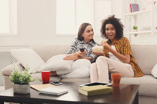 Lächelnde Freundinnen, die zu Hause fernsehen — Stockfoto